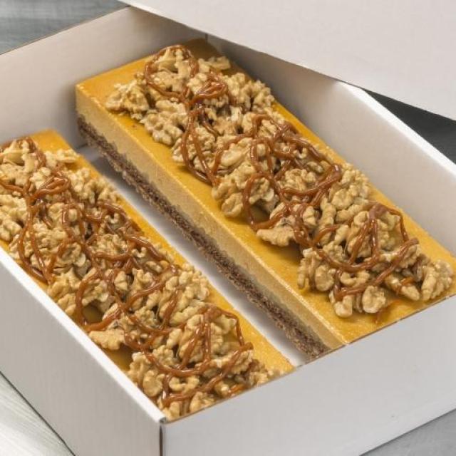 Longeur appel-caramel met een bodem van melkchocoladecrunch en een decoratie van walnoot met carameltopping