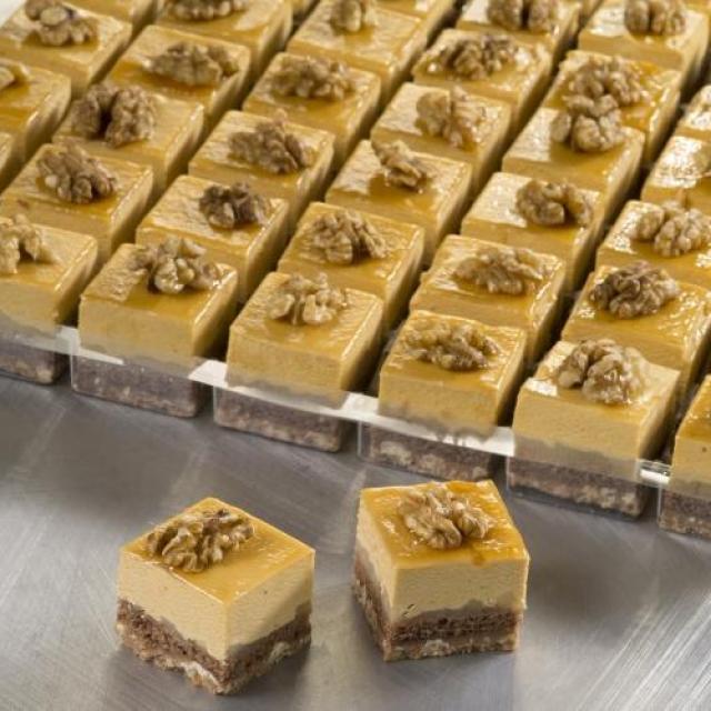 Petit four appel-caramel met een bodem van melkchocoladecrunch en een decoratie van walnoot