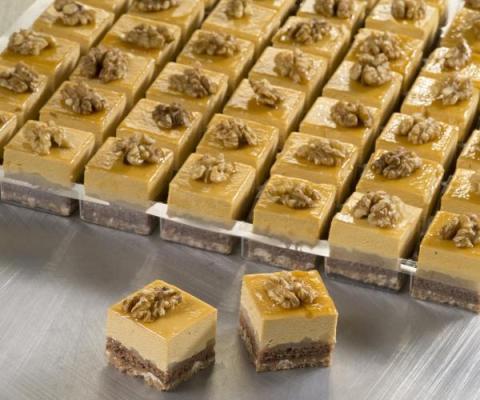 Petit four appel-caramel met een bodem van melkchocoladecrunch en een decoratie van walnoot